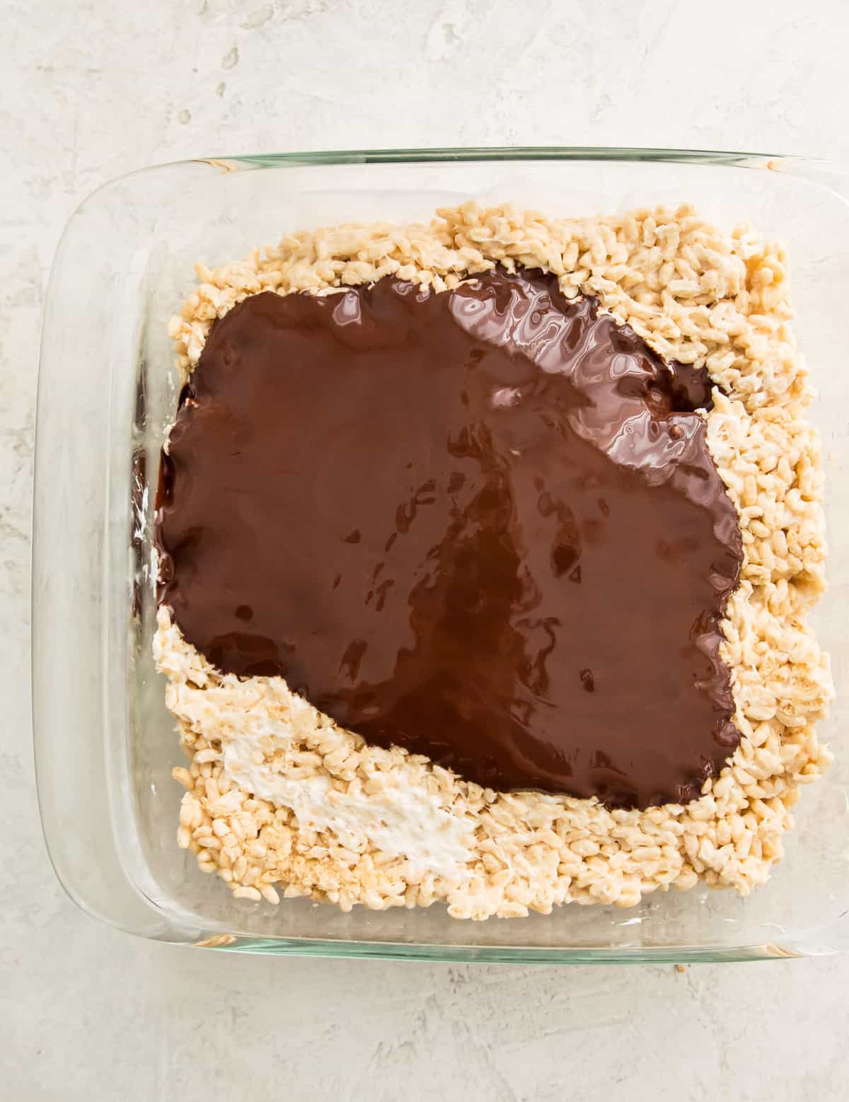 A pan of Rice Krispie Treats covered in melted chocolate. 