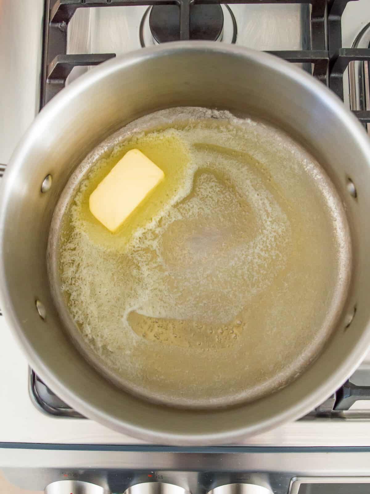 Butter melting in a pot on the stovetop.