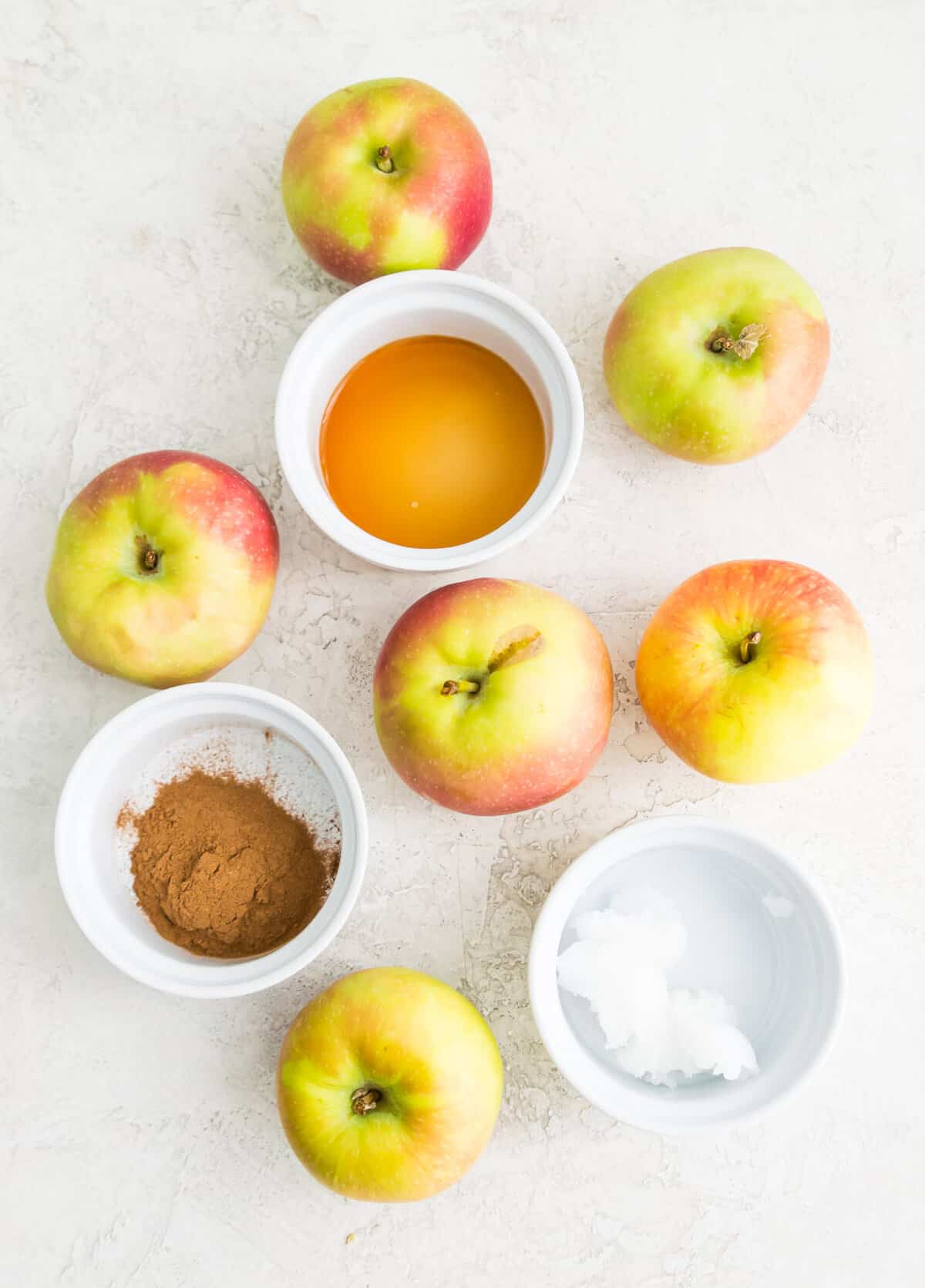 The ingredients needed to make a homemade, sugar free applesauce, separated into small bowls. 