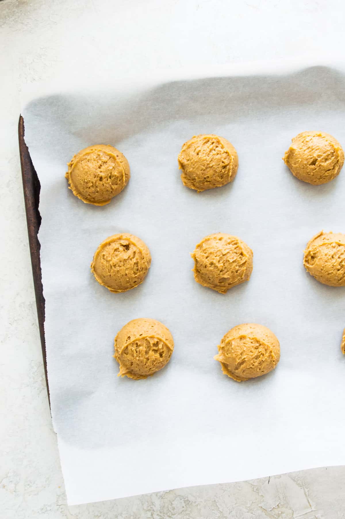 A baking sheet with cookie dough on it.