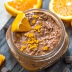 A jar of chocolate orange overnight oats garnished with orange zest.