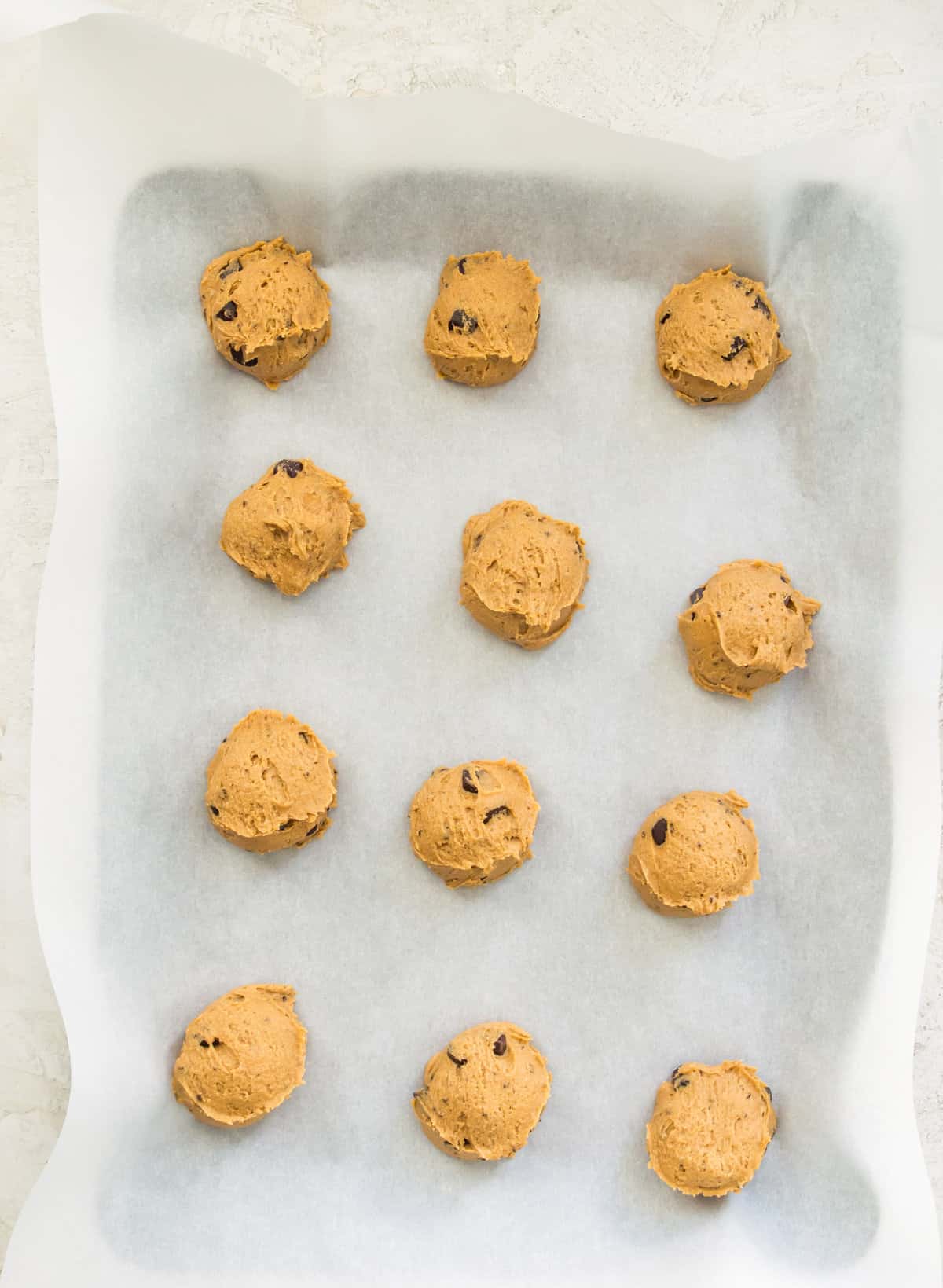 Cookie dough on a baking sheet lined with parchment paper.