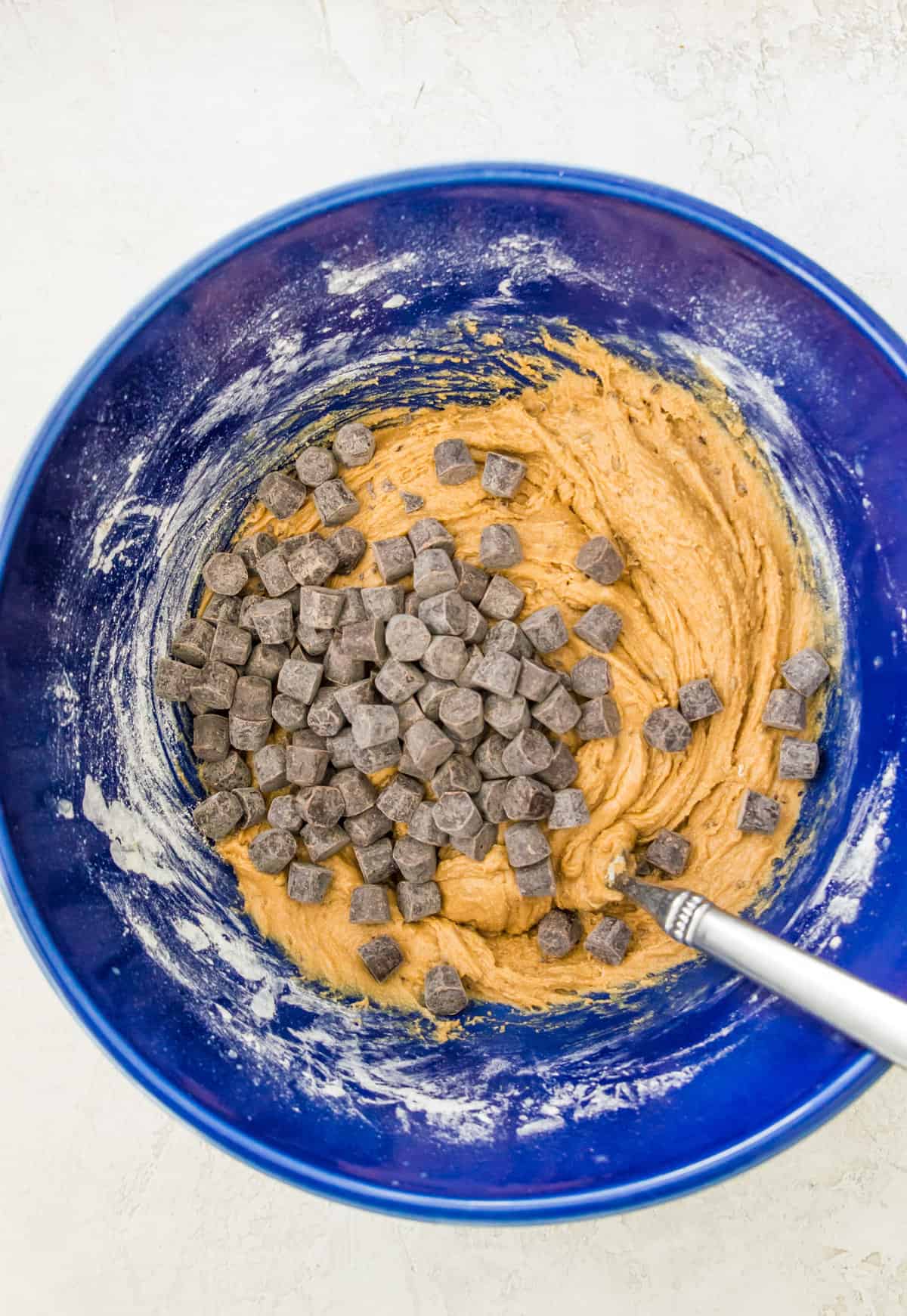 A bowl with cookies dough and chocolate chips in it.