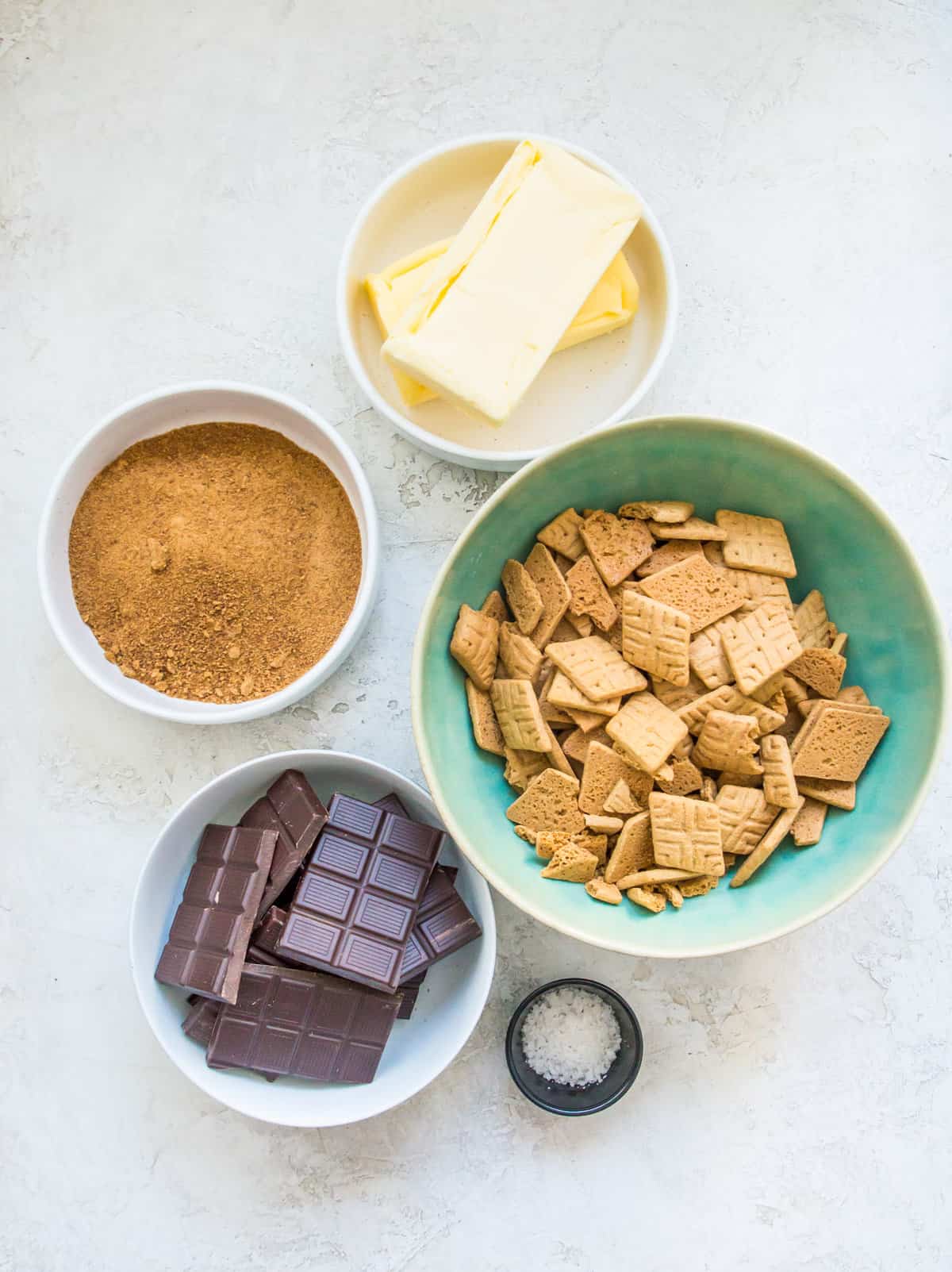 The ingredients needed to make graham cracker Christmas crack separated into bowls. 