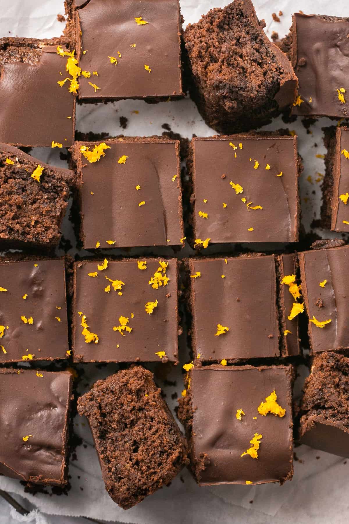Paleo orange chocolate brownies cut into pieces and garnished with orange zest. 