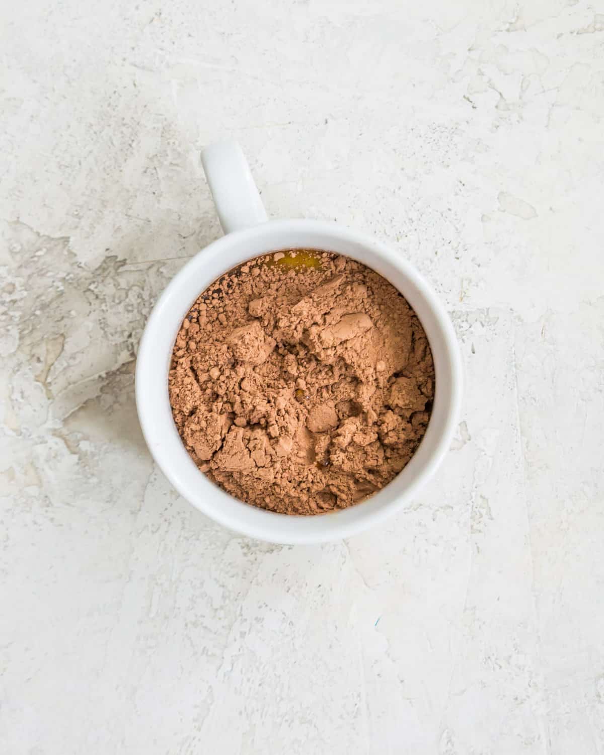 A mug filled with cocoa powder. 