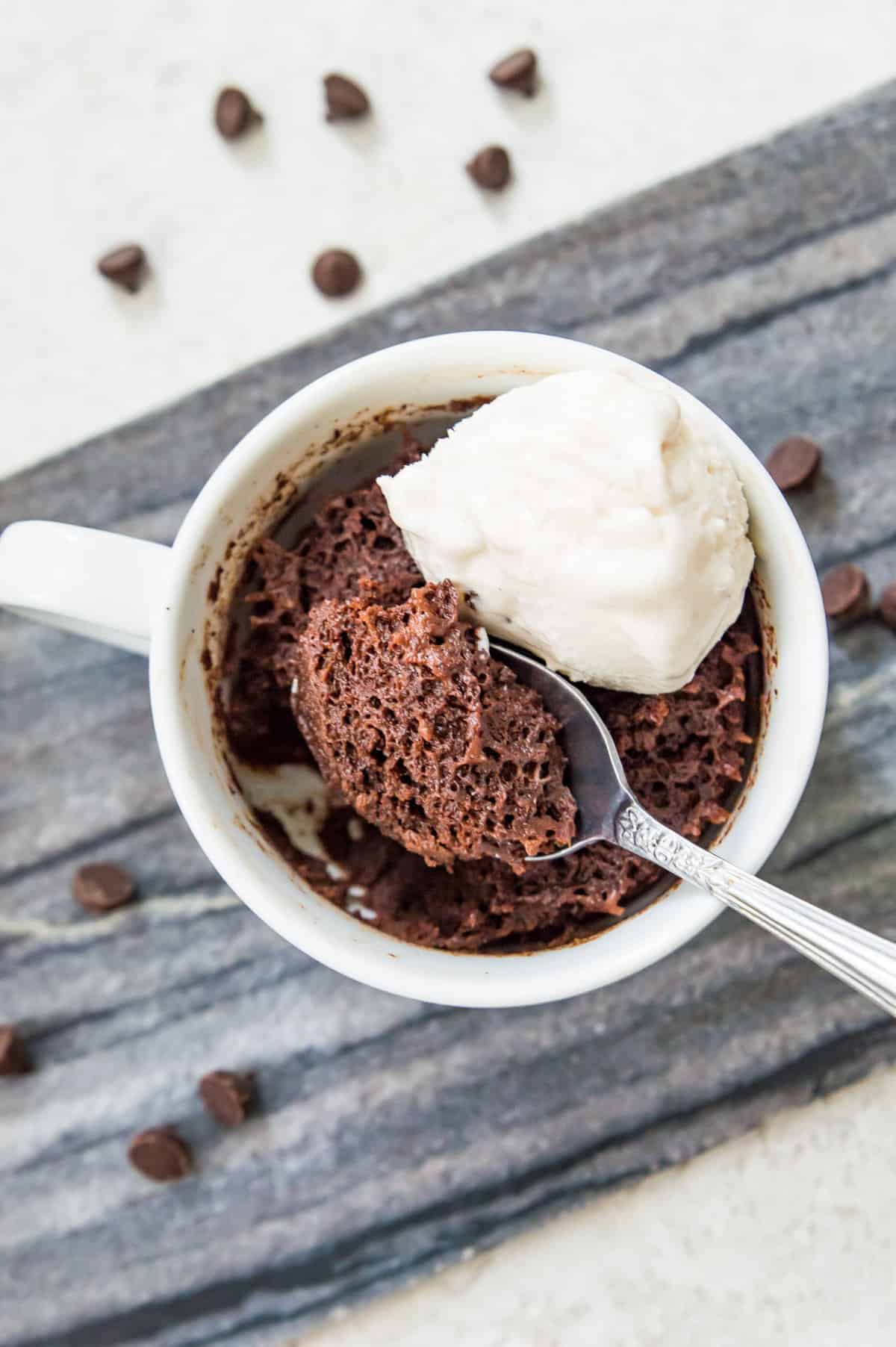 A 3 ingredient chocolate mug cake topped with vanilla ice cream.