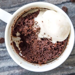 A mug filled with a 3 ingredient mug cake topped with vanilla ice cream.