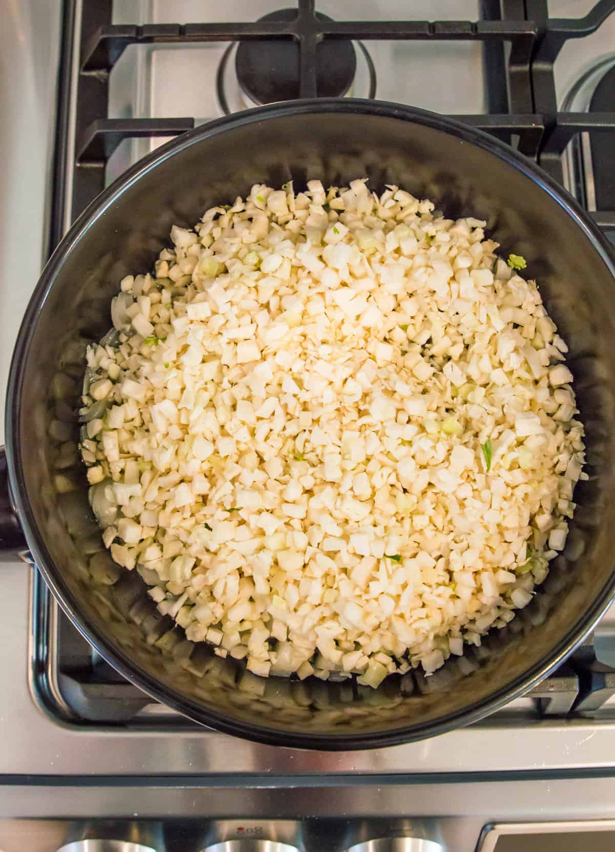 A pan full of cauliflower rice on the stovetop.