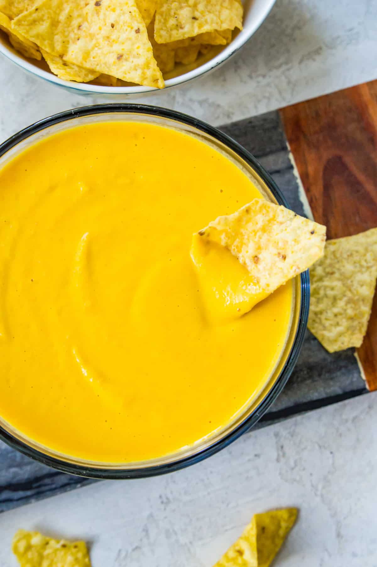 A bowl of vegan cheese sauce with a nacho chip in it.