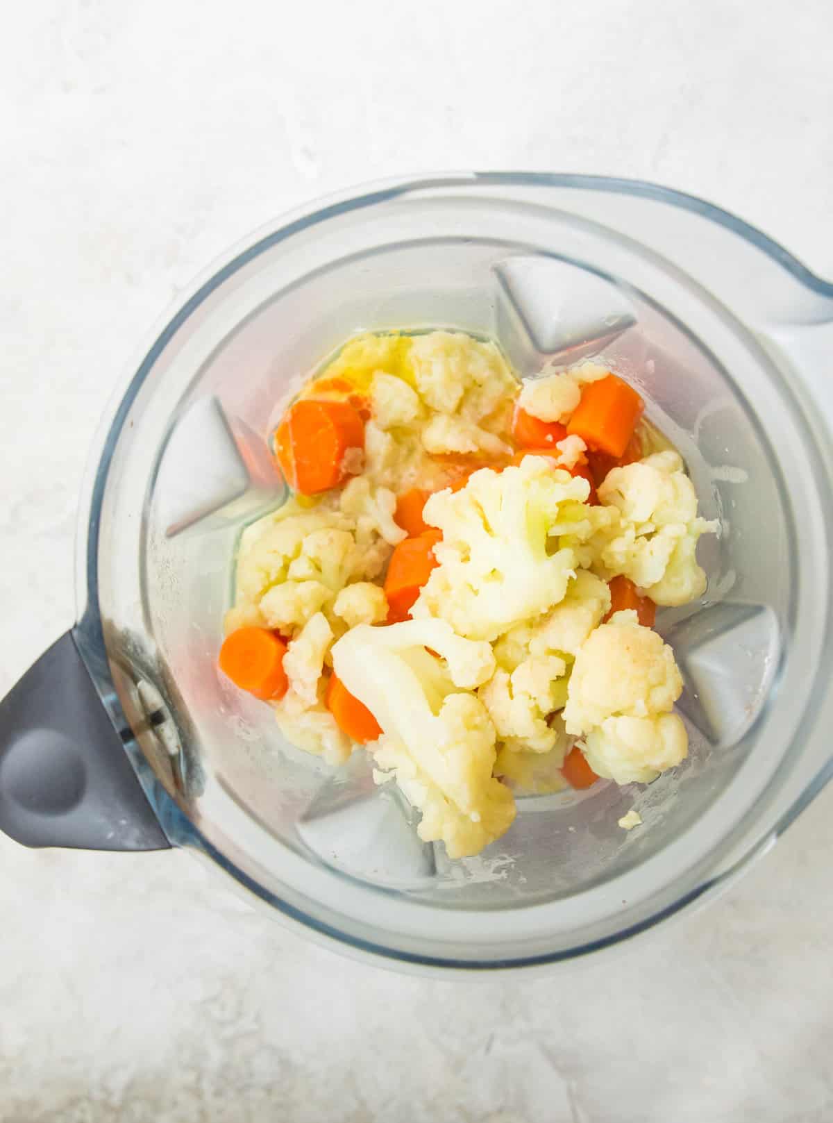Steamed cauliflower and carrots in a blender with coconut milk and nutritional yeast. 