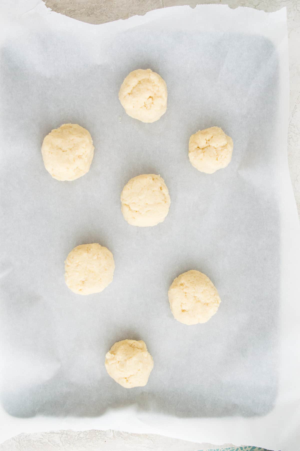 Uncooked biscuits on a baking sheet with parchment paper. 