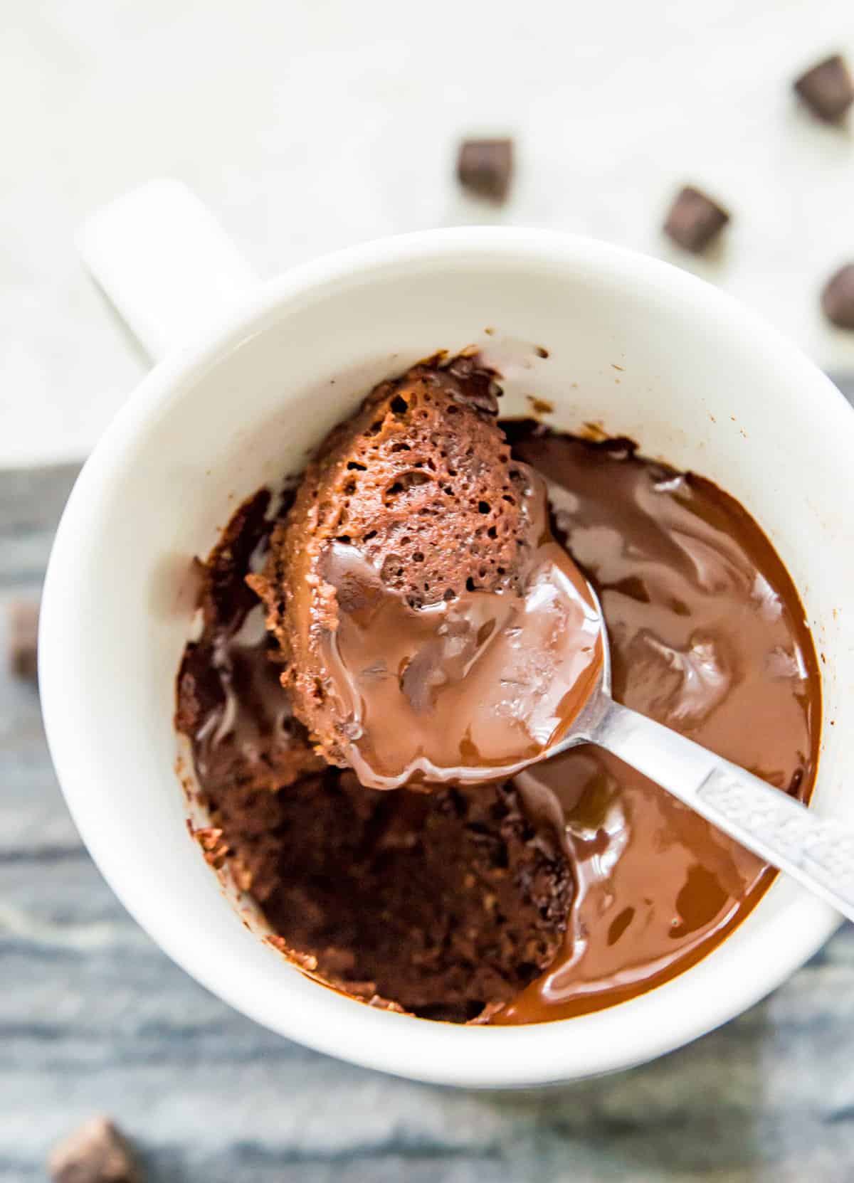 A chocolate mug cake made with almond flour with a spoon in it.