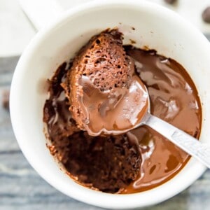 A chocolate almond flour mug cake with a spoon in it.