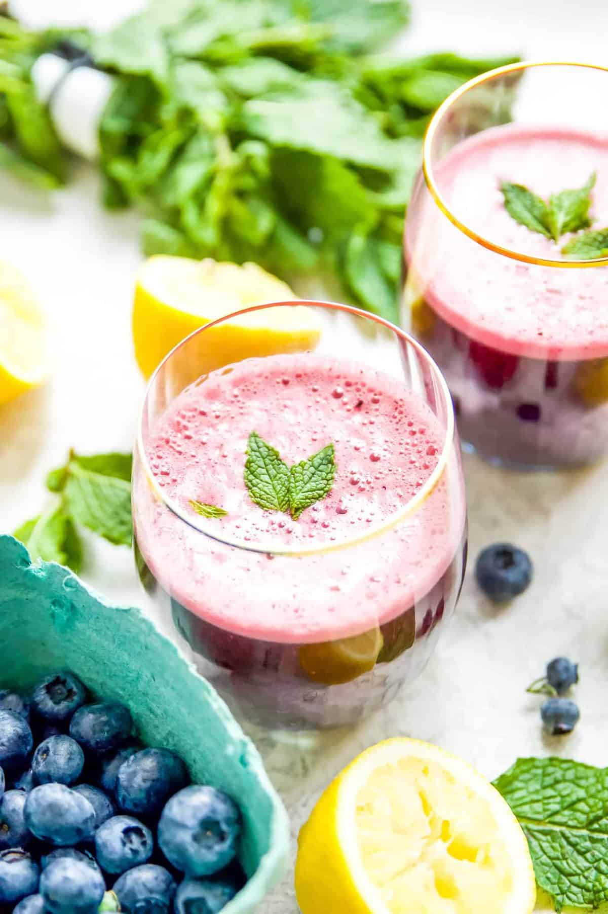 Glasses of pink lemonade garnished with mint leaves.