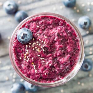 A jar of blueberry chia jam topped with a fresh blueberry and white chia seeds.