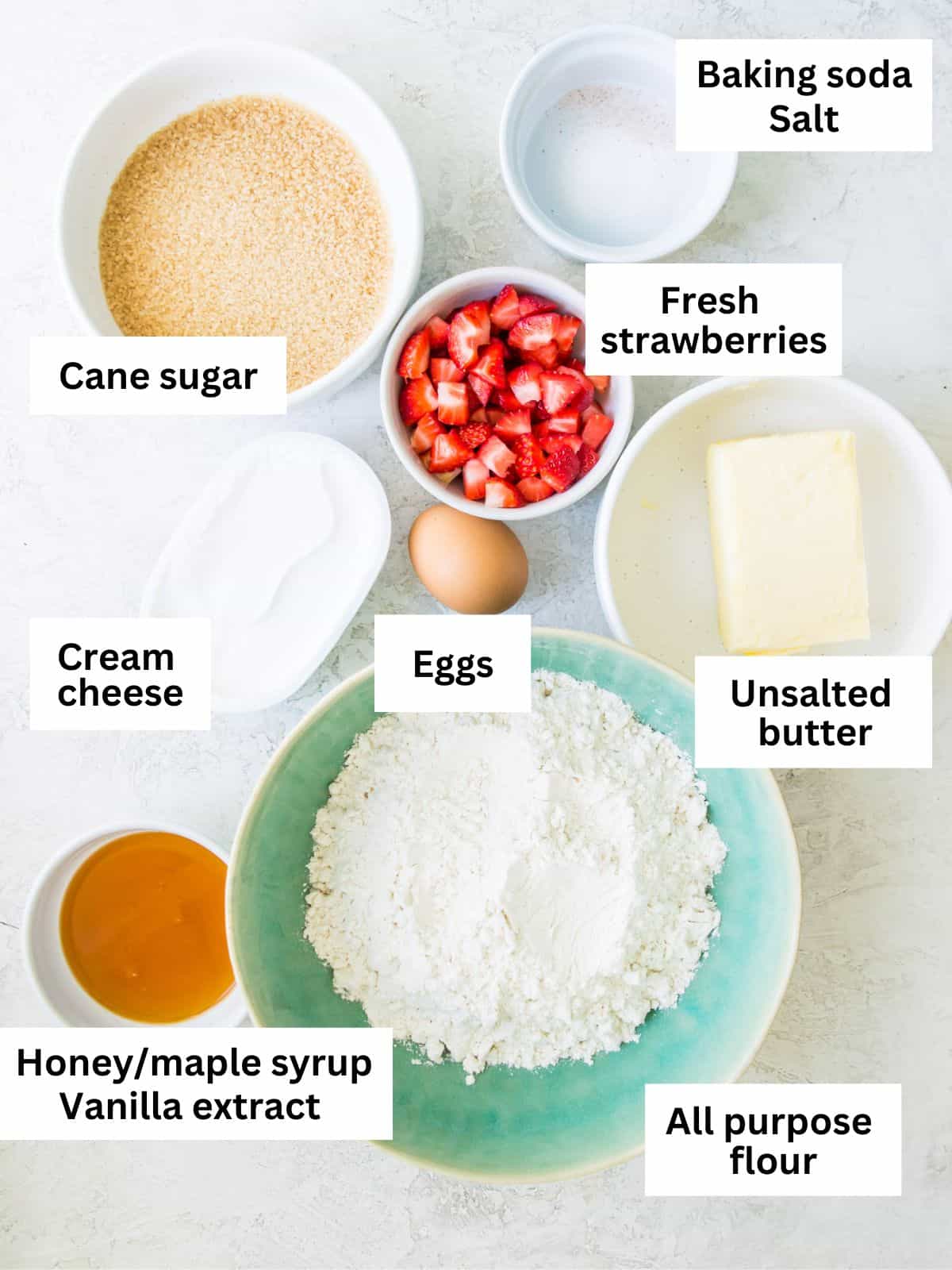 The ingredients needed to make strawberry cheesecake cookies separated into small bowls. 