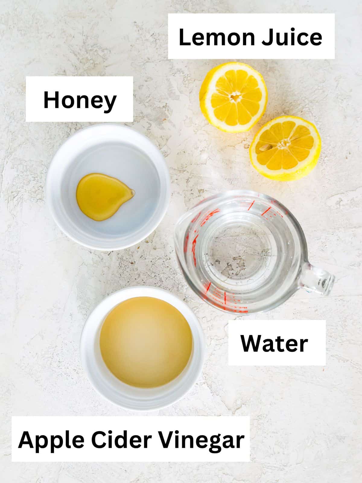 The ingredients needed to make an apple cider vinegar and lemon juice drink separated into small bowls. 