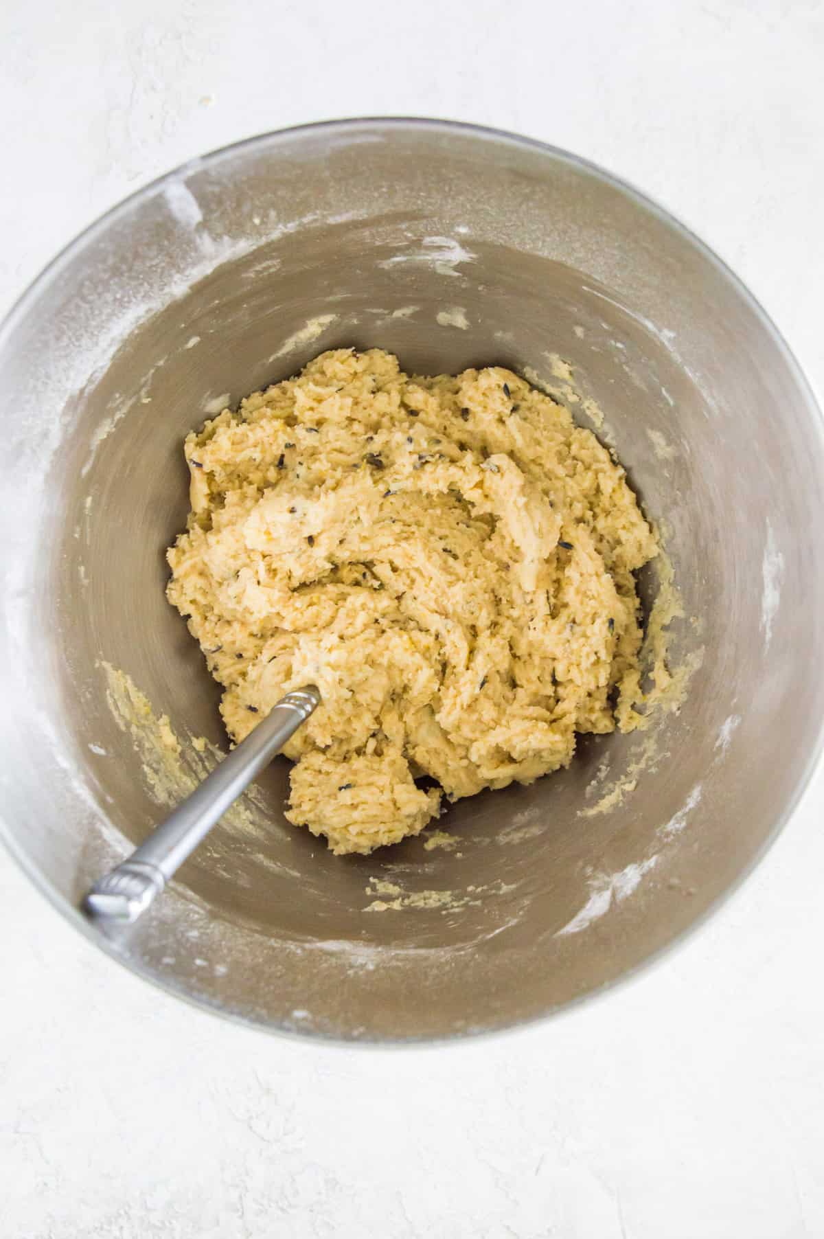 Cookie dough in a large bowl with a spoon in it.