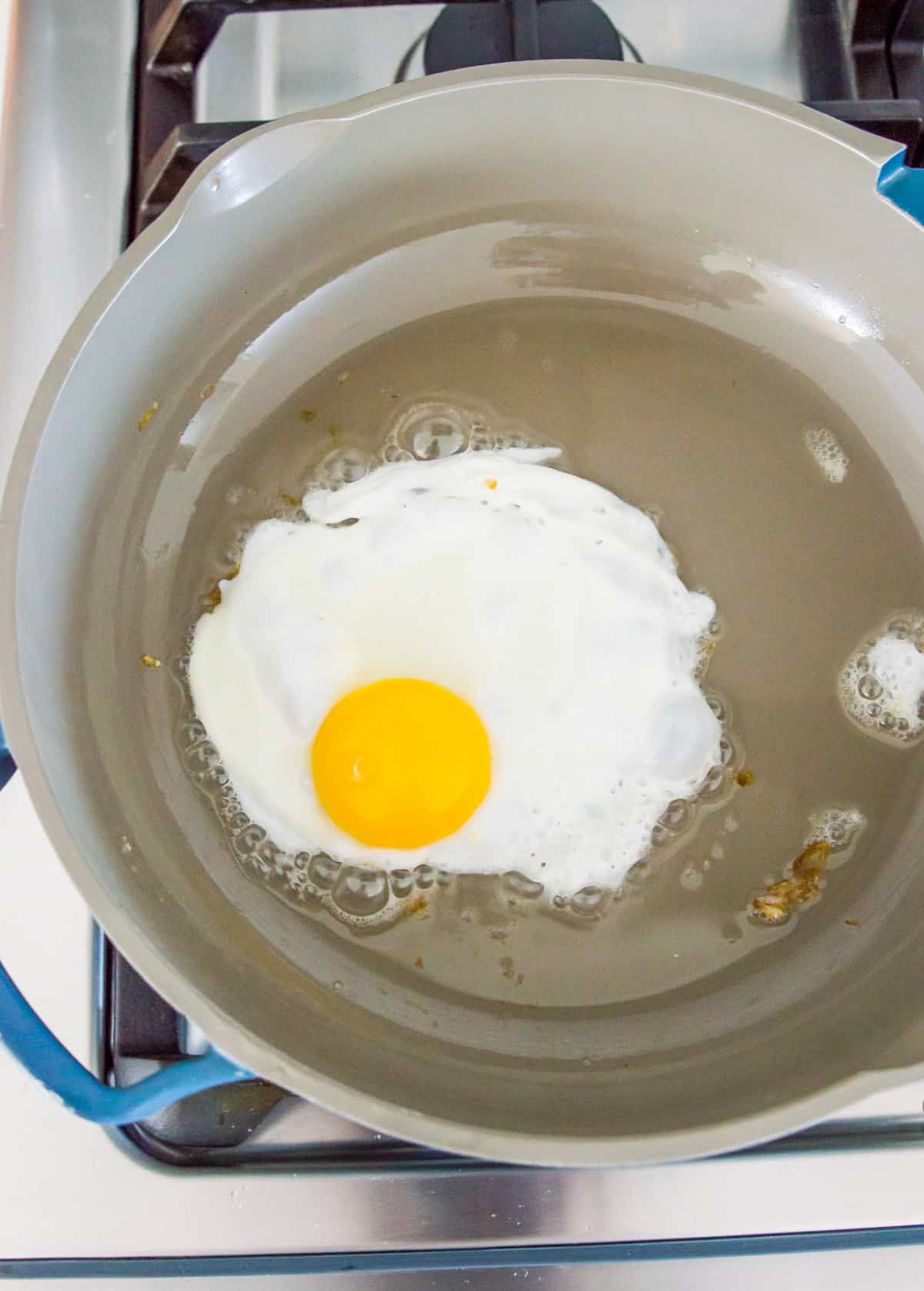 An egg being fried in a frying pan.