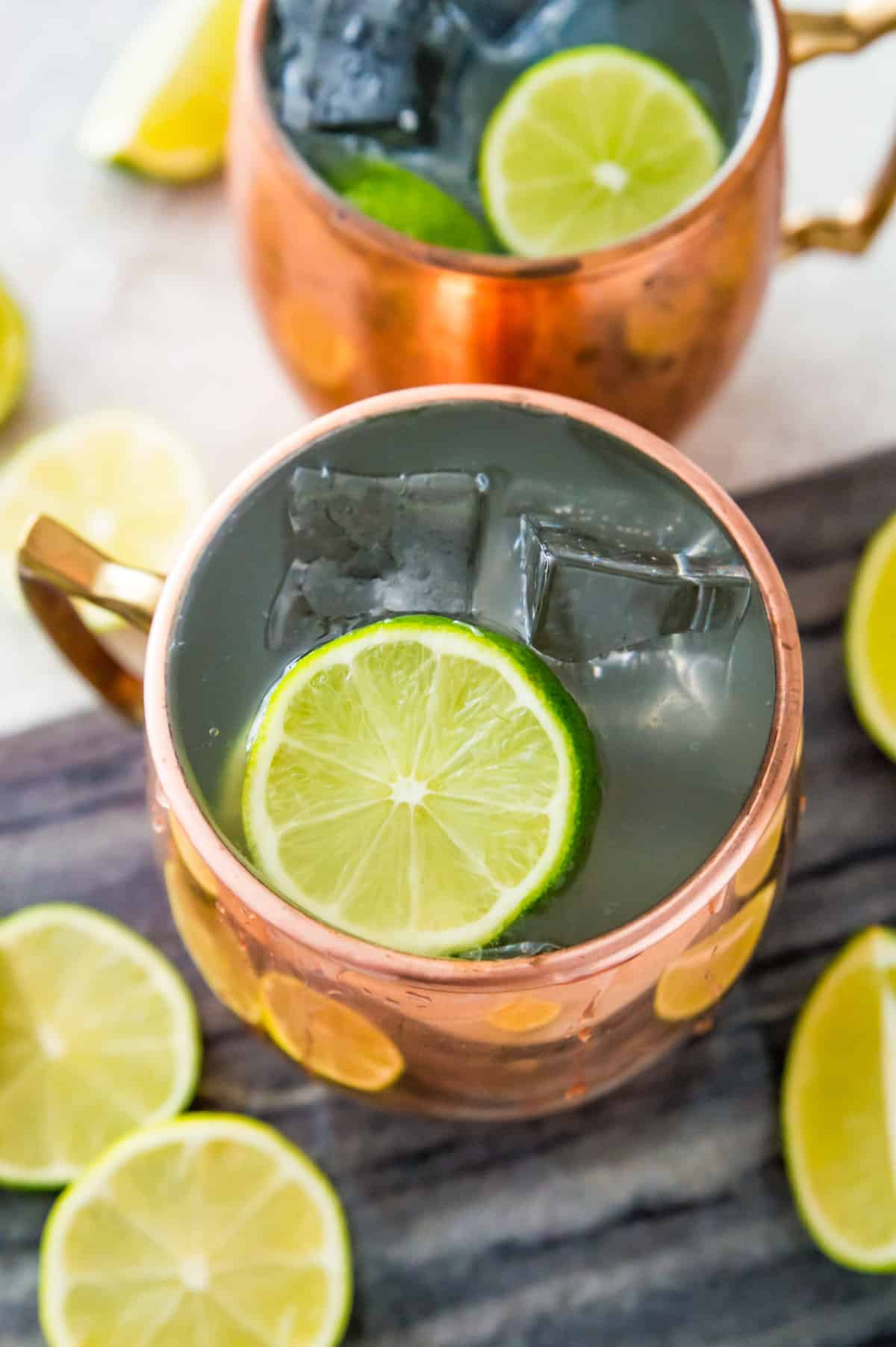 A virgin Moscow mule in a copper mug with ice and lime slices in it.
