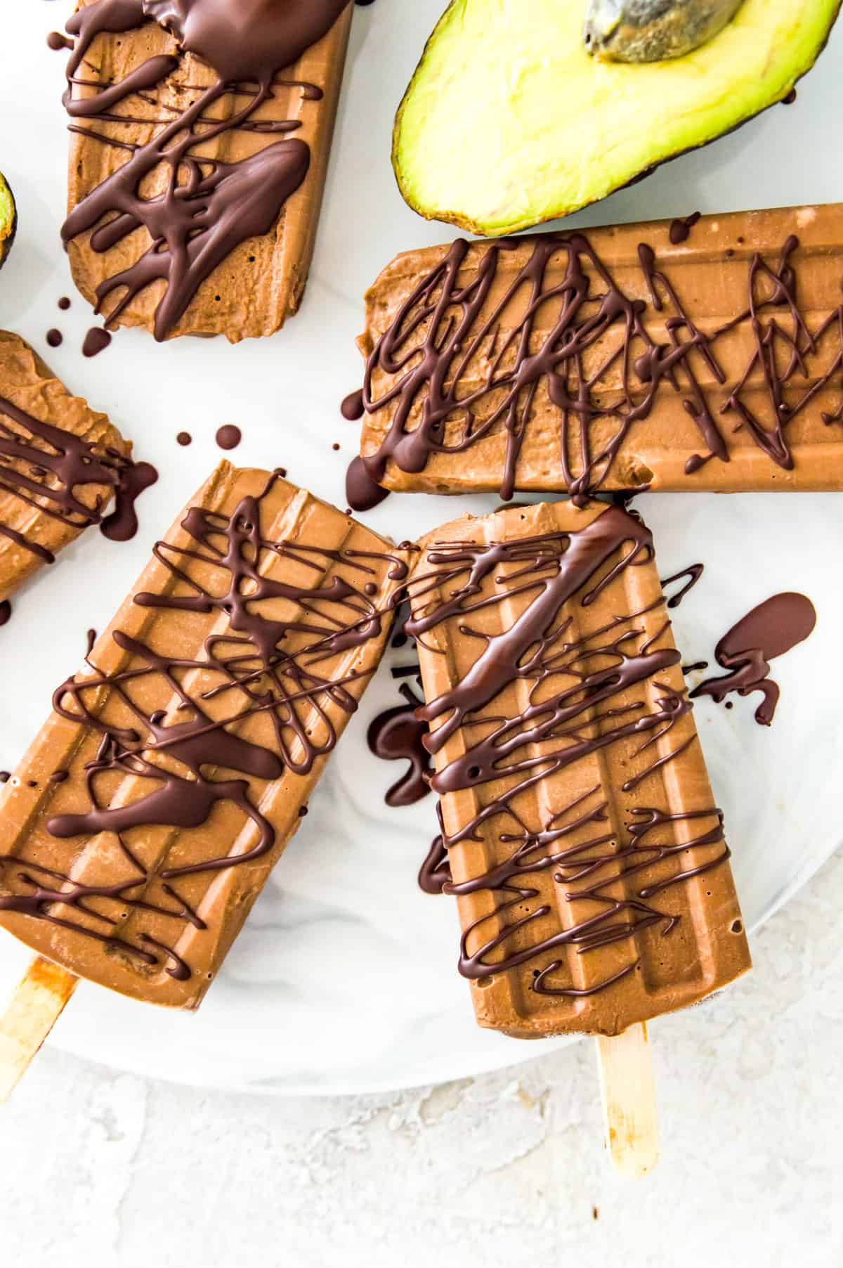 Chocolate popsicles drizzled in melted chocolate on a serving tray.