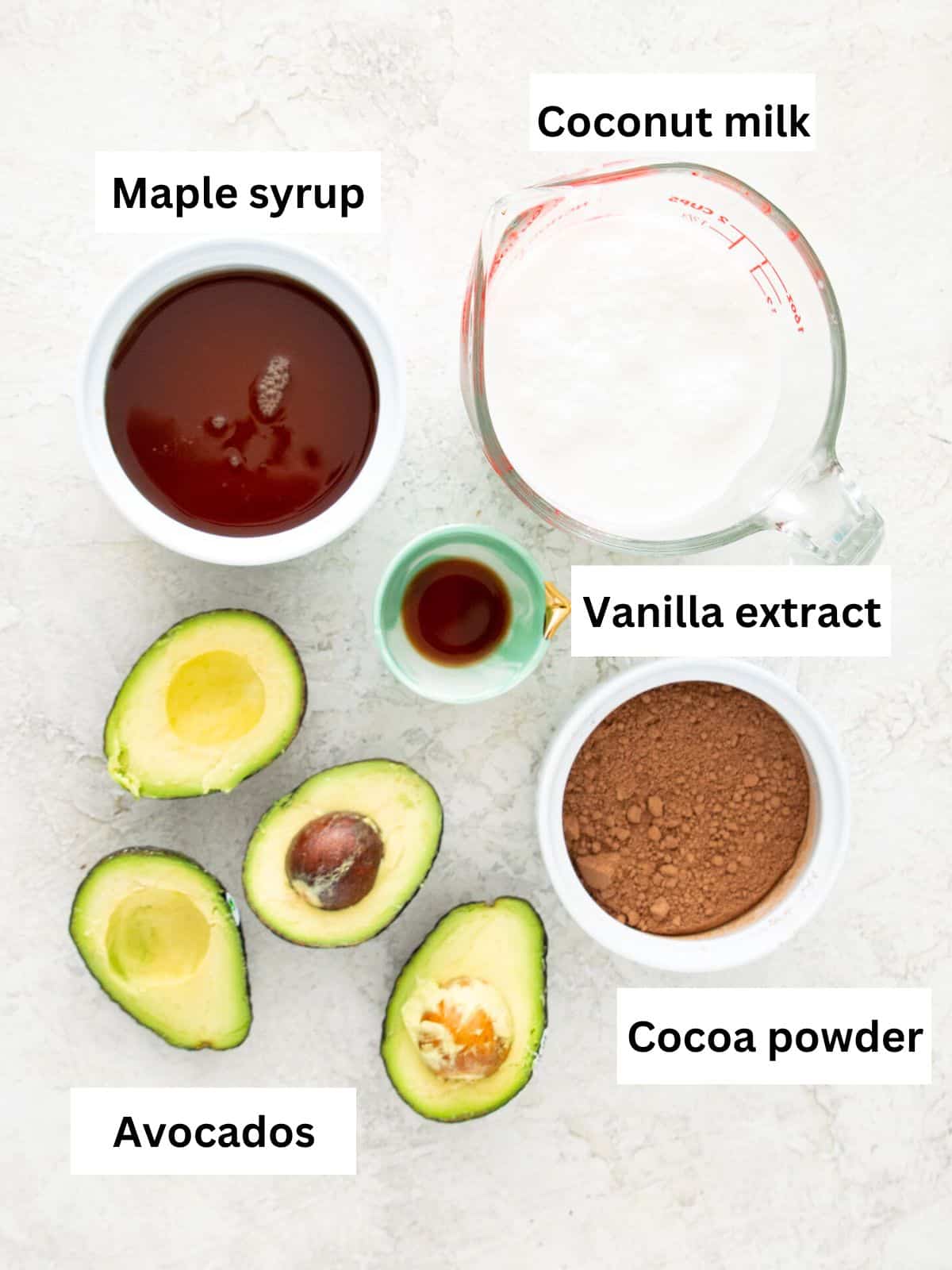 The ingredients needed to make avocado fudgesicles separated into small bowls. 