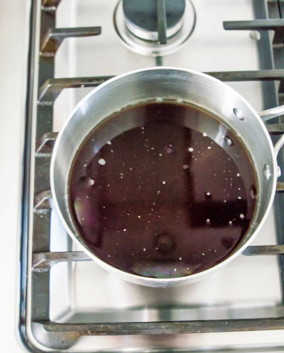 Brown sugar and water in a pot on the stovetop.