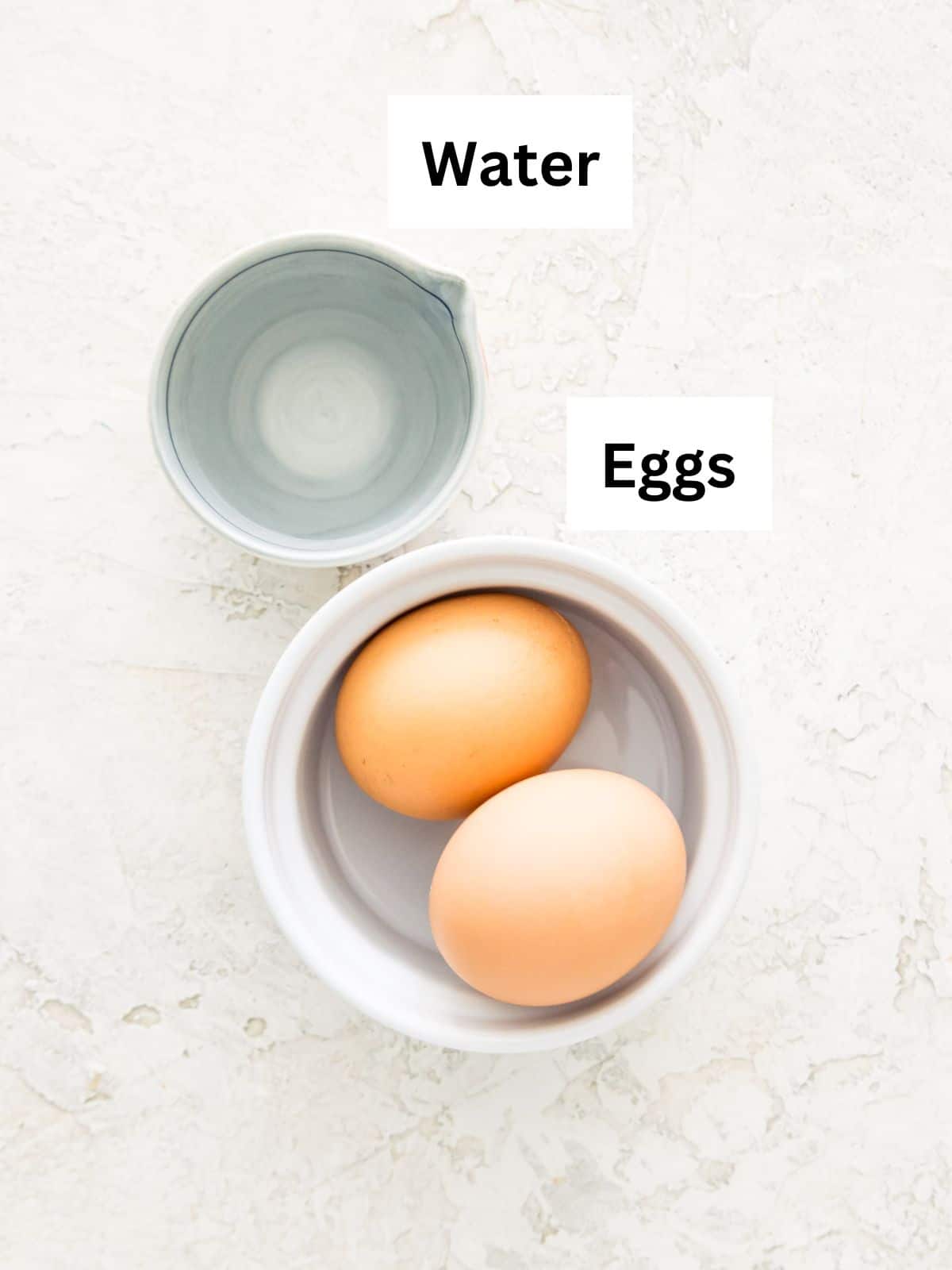 Water in a measuring cup and eggs in a white bowl.