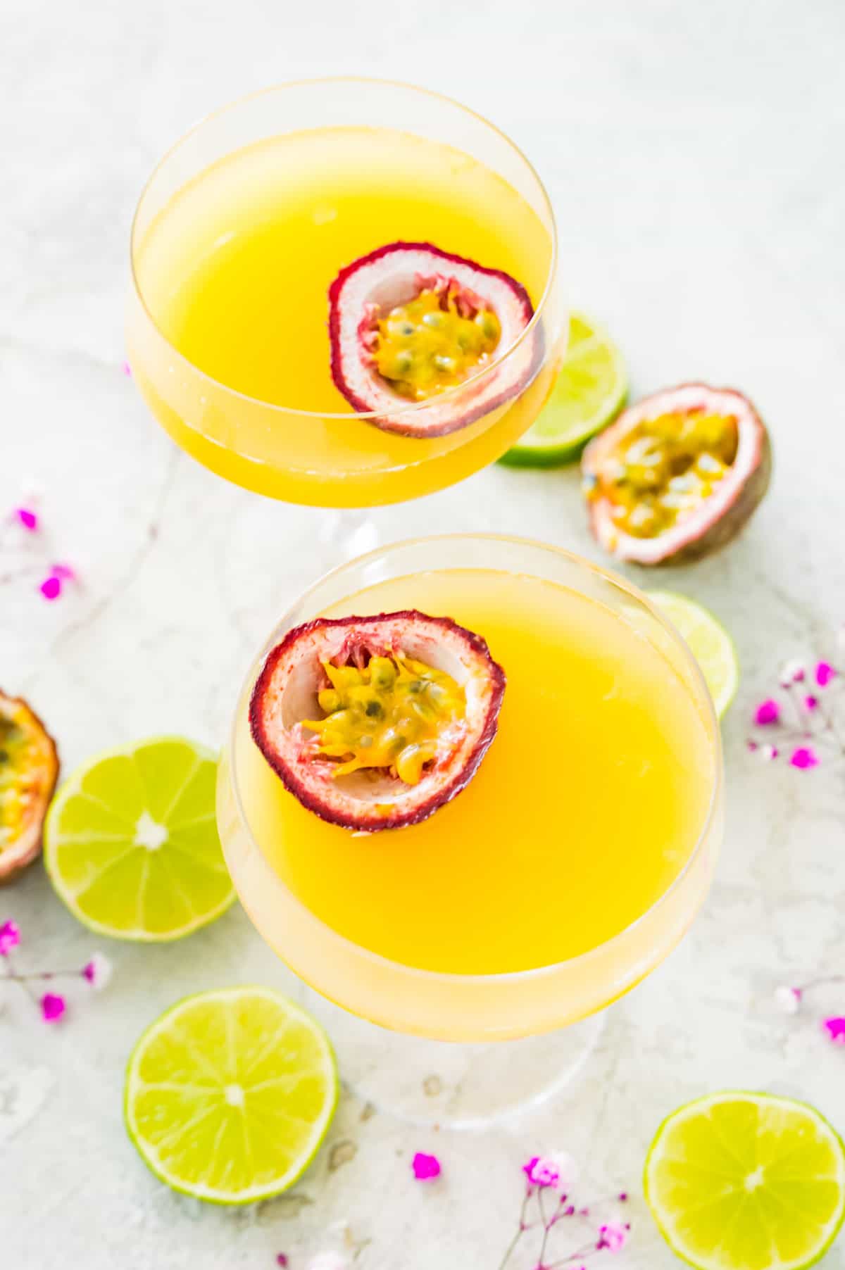 Passion fruit cocktails in martini glasses garnished with passion fruit halves. 