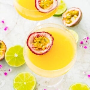 A pornstar martini mocktail in a martini glass with a passion fruit half in it.