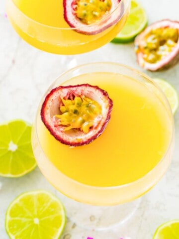 A pornstar martini mocktail in a martini glass with a passion fruit half in it.