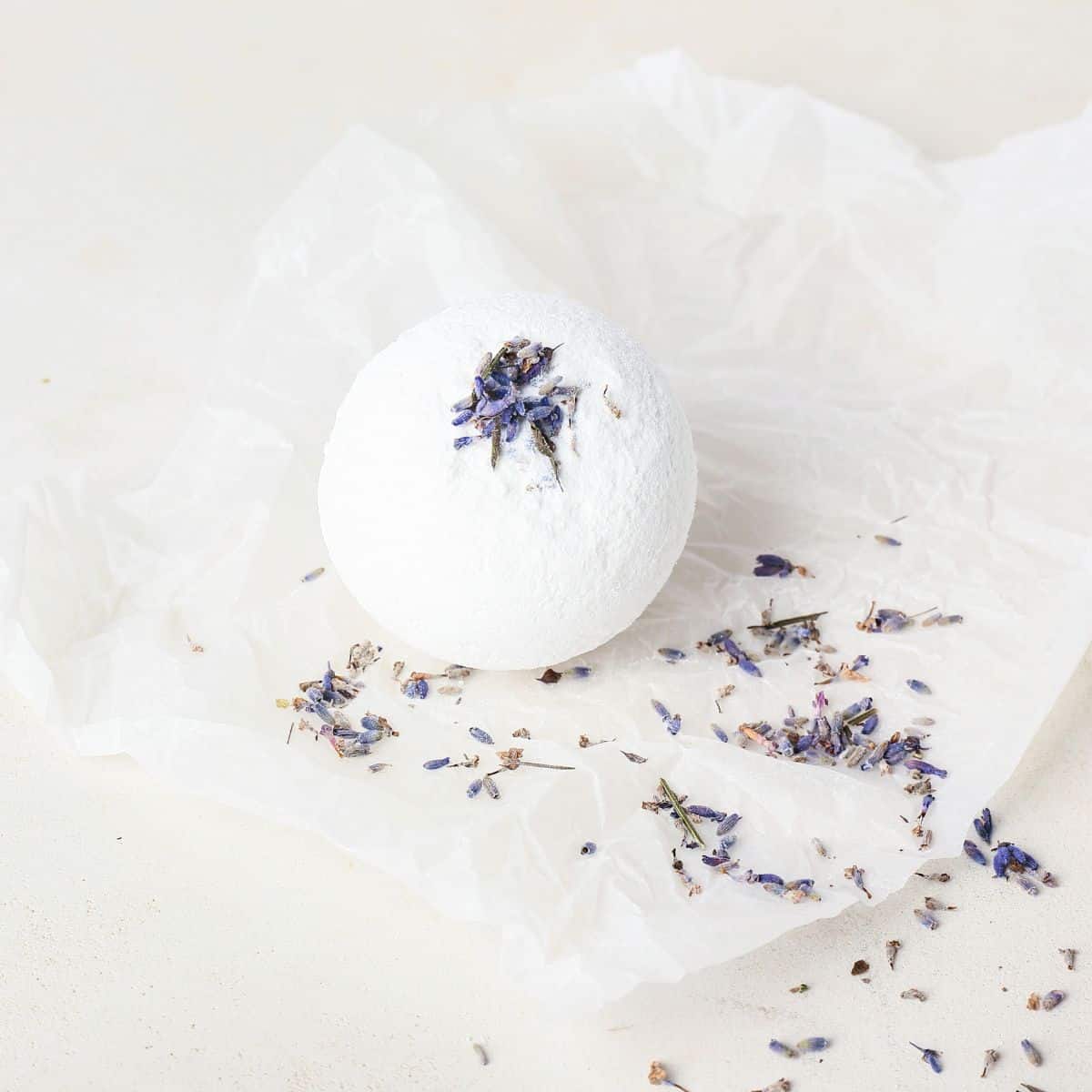 A white bath bomb with dried lavender flowers in it.