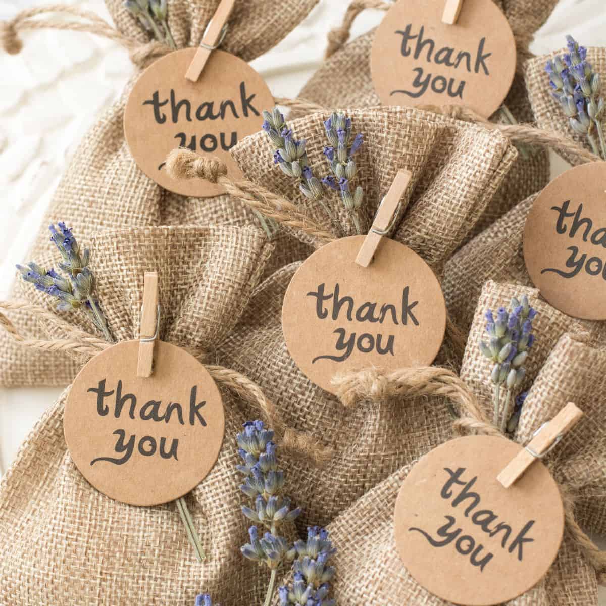 Small cloth bags with a tag saying thank you pinned to it with clothes pins.