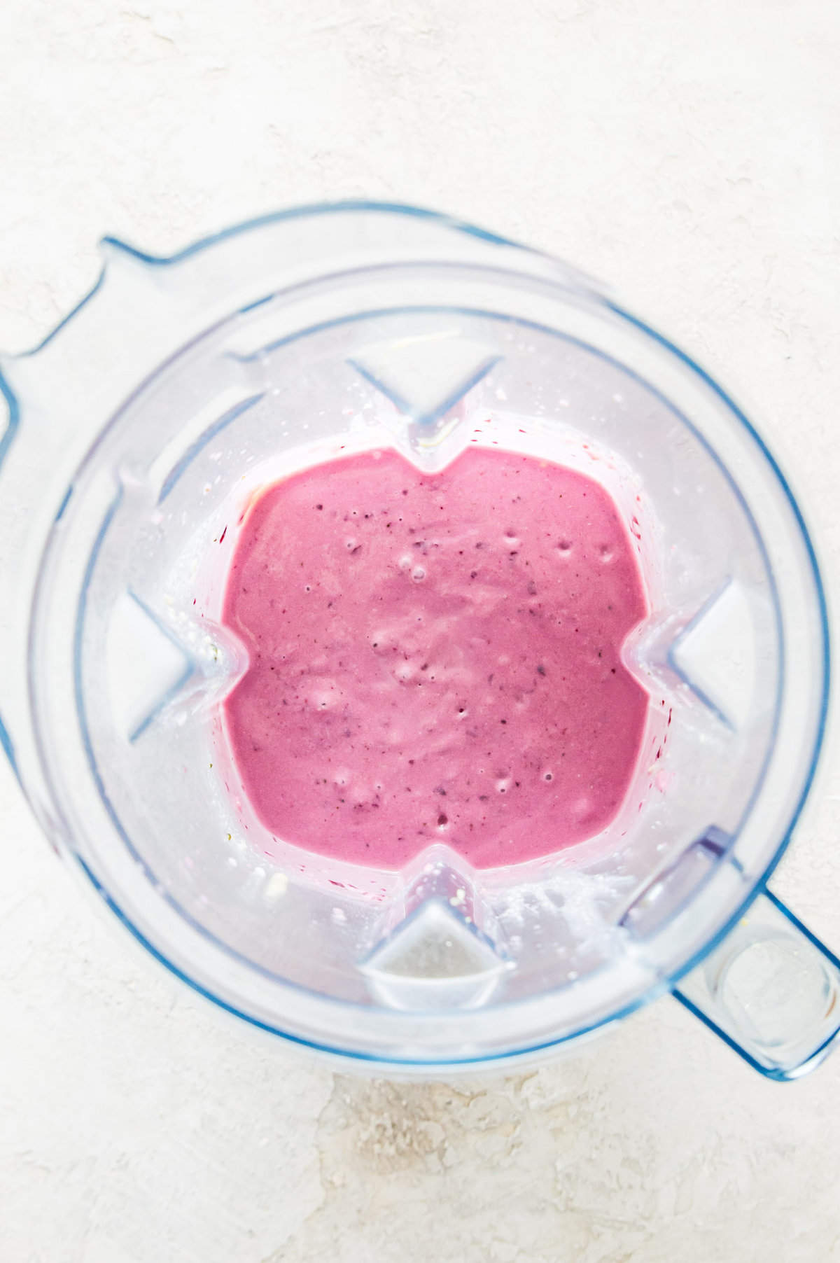 A blender filled with a pink smoothie.