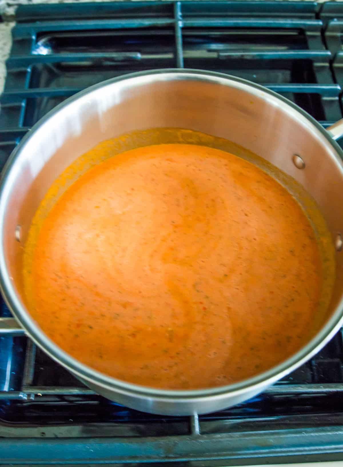 A tomato soup in a pot on the stovetop.