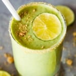 A glass of key lime pie smoothie topped with a lime slice and graham cracker crumbs.
