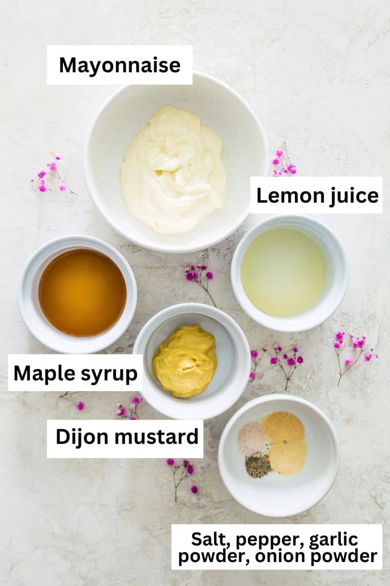 The ingredients needed to make a mustard aioli sauce separated into small bowls. 