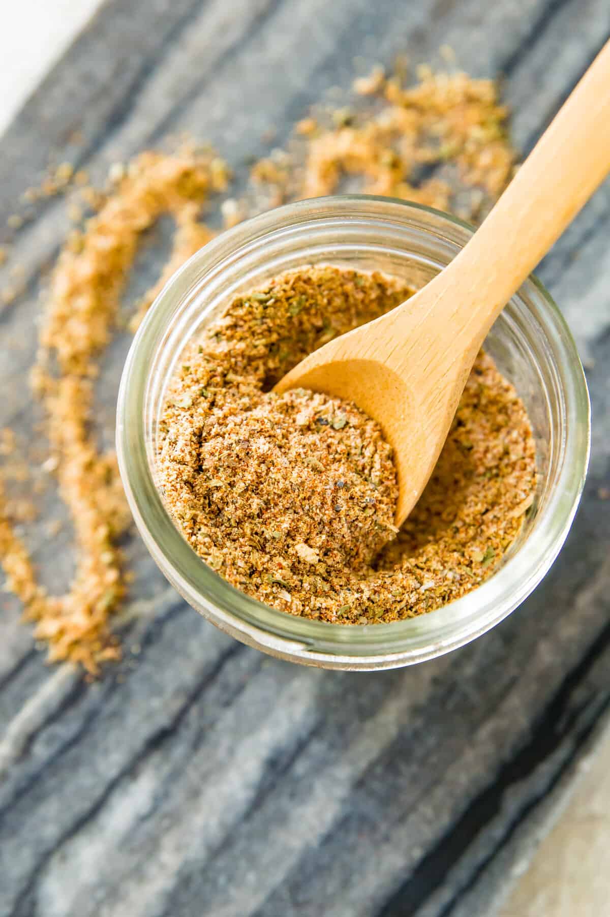 A jar of chicken taco seasoning mix with a wooden spoon in it.