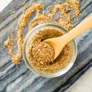 A jar of chicken taco seasoning mix with a wooden spoon in it.