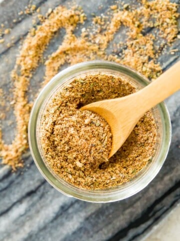 A jar of chicken taco seasoning mix with a wooden spoon in it.