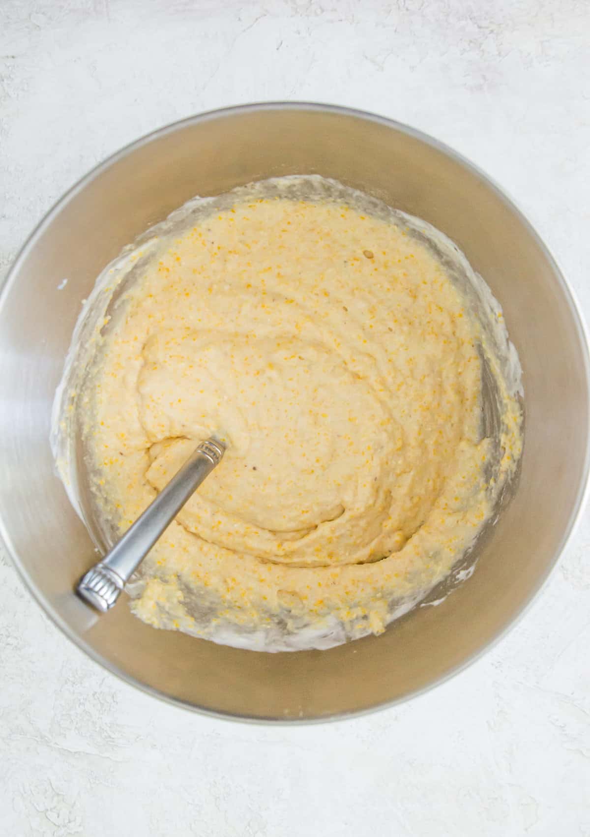 A large bowl with cornbread batter in it.