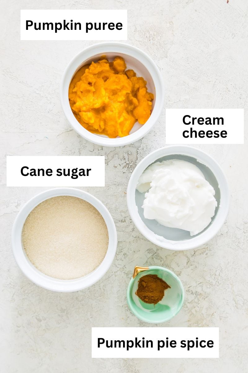 Pumpkin puree, cream cheese, cane sugar and pumpkin pie spice all separated into small bowls. 