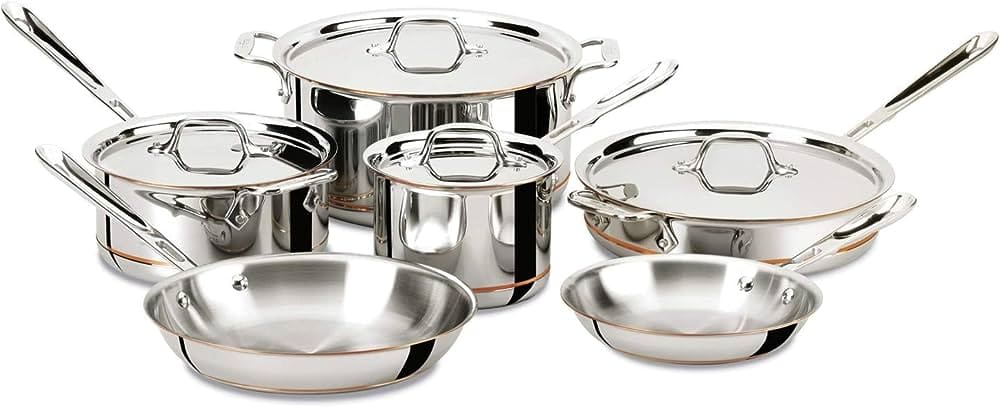 A set of All Clad stainless steel lined copper core cookware including pots and pans of different sizes. 