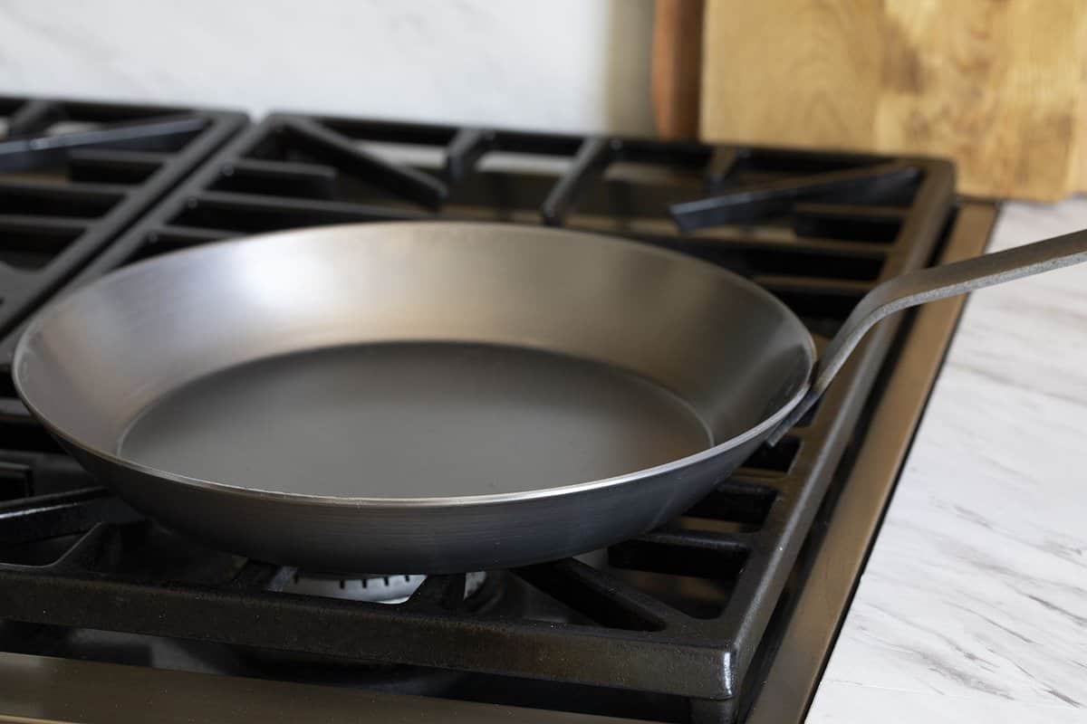 A carbon steel pan on a stovetop.