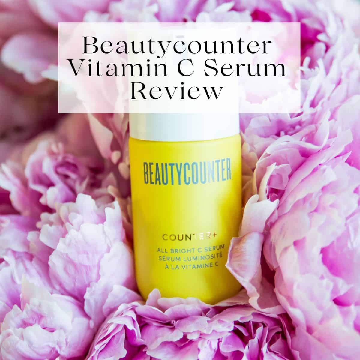 A bottle of Beautycounter's vitamin C serum on top of pink peonies with the title Beautycounter Vitamin C Serum Review over it.