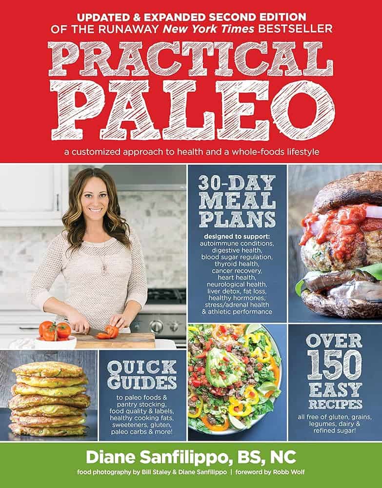 A book called Practical Paleo with a girl cutting tomatoes in the kitchen on the cover. 