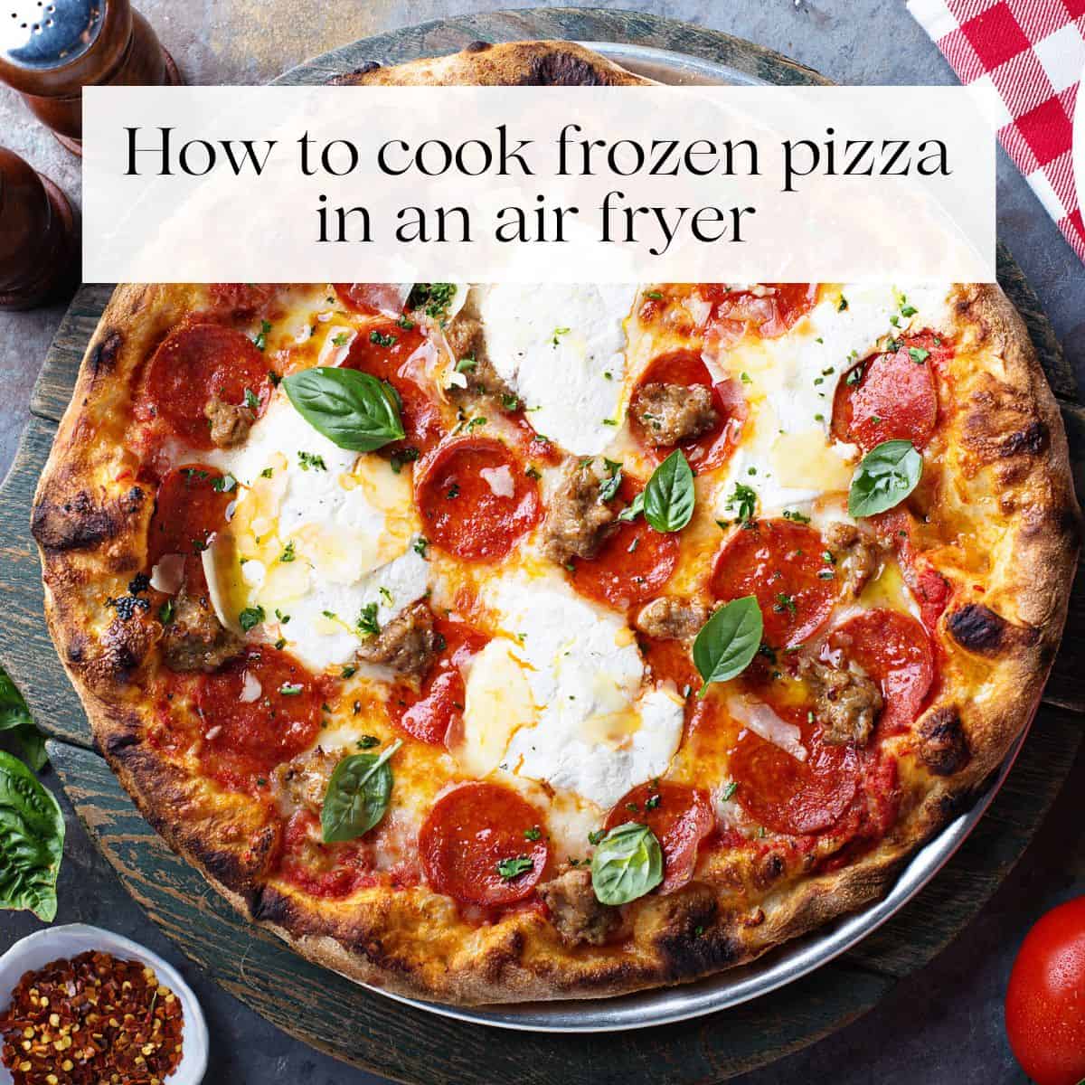 A cooked pizza topped with cheese, pepperoni slices and fresh basil with the title "how to cook frozen pizza in an air fryer" over it.