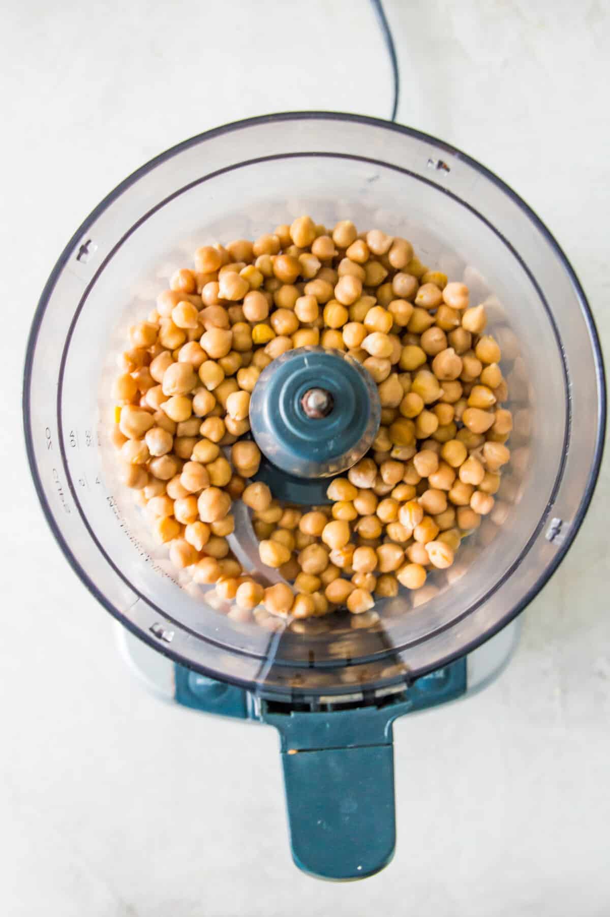 A food processor filled with chickpeas.