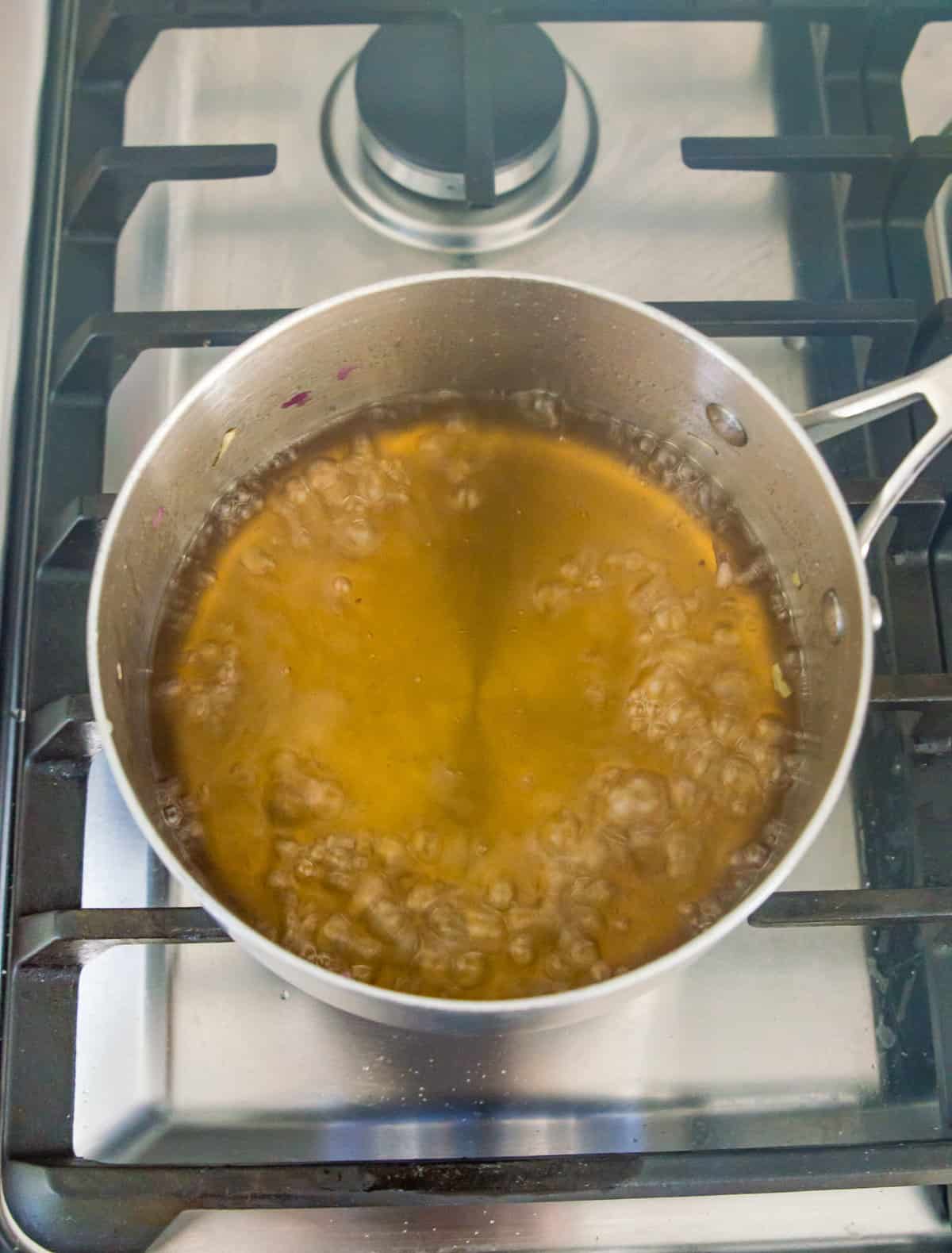 A simple syrup simmering in a pot on the stovetop.